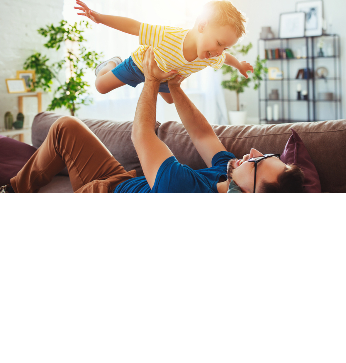 Father and son playing joyfully on the couch