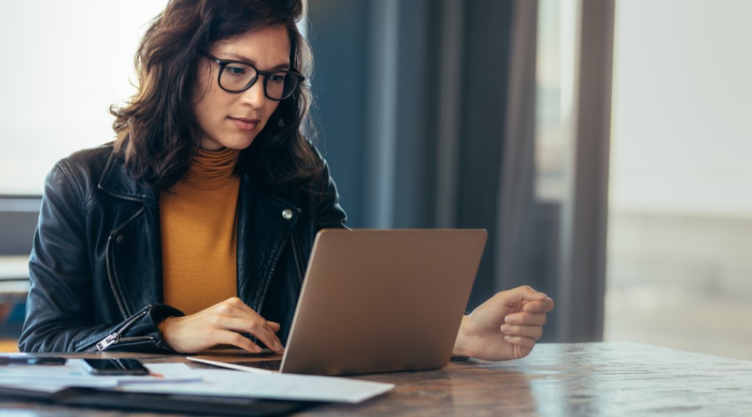 Lady with glasses looking seriously at a laptop